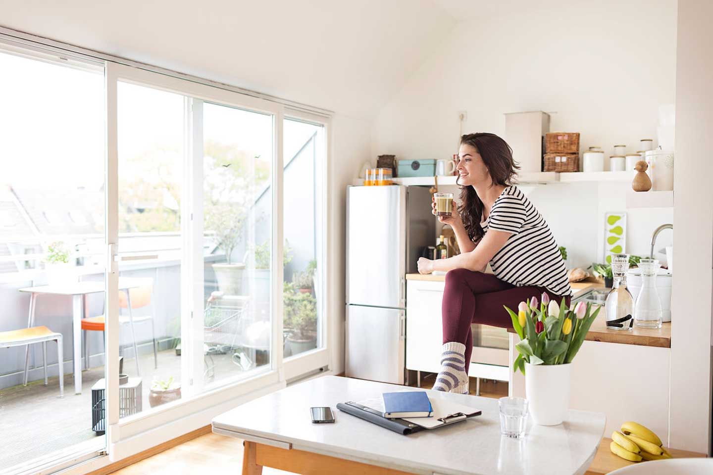 a woman is sitting on a table drinking a cup of coffee .