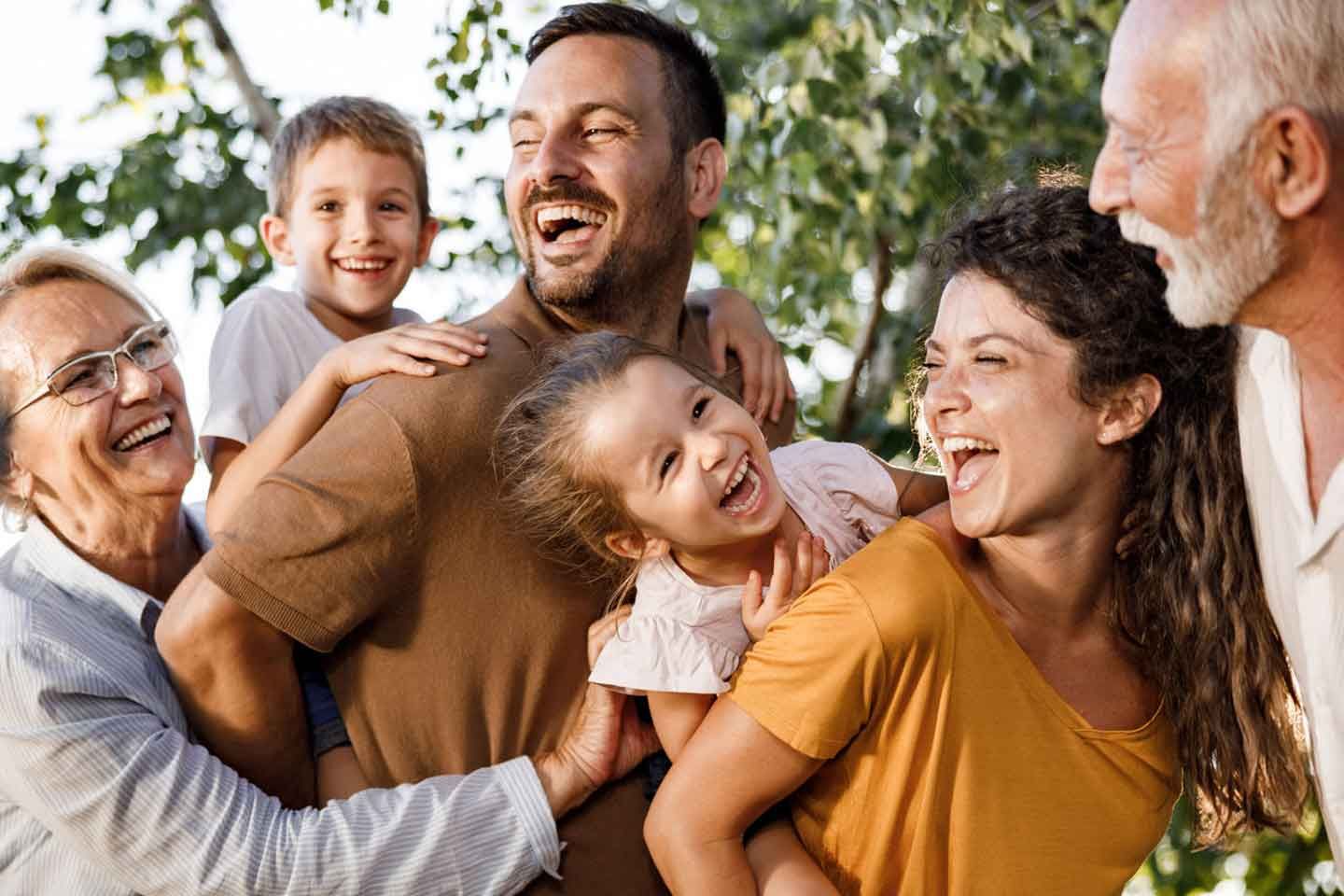 a large family is posing for a picture together in a park .